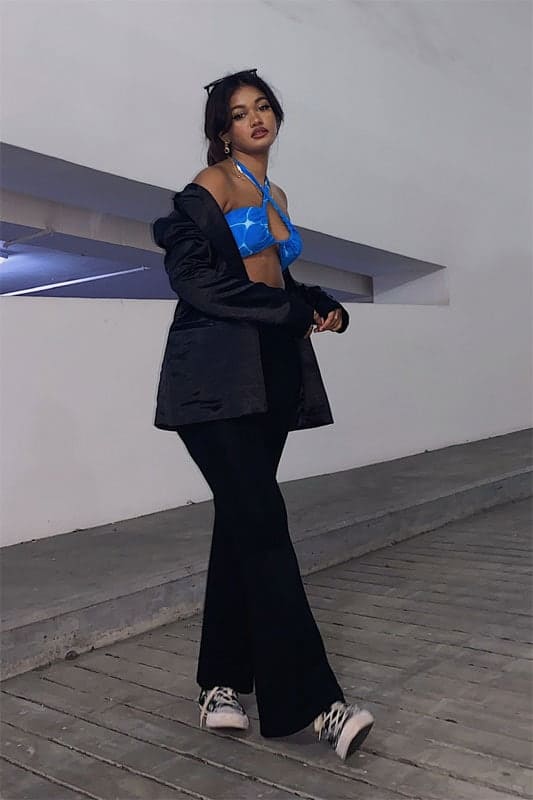Pairing a swimwear-inspired top from Pomelo with Converse High-tops, Shavita throws on black bellbottoms and a black blazer from Bebe to finish off her look